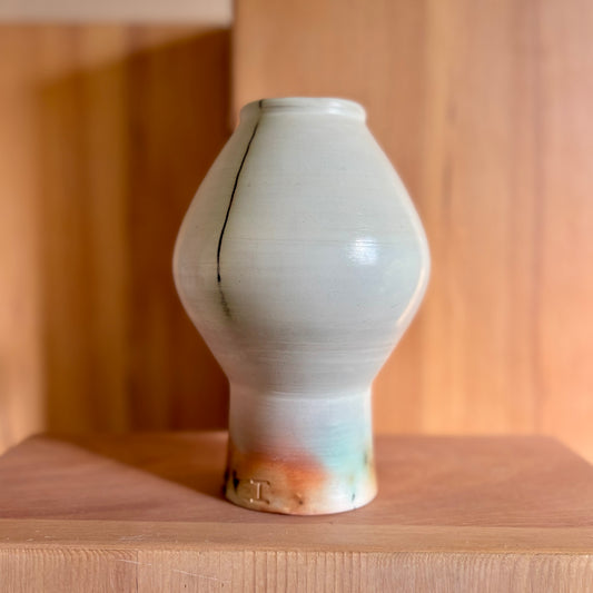 An elevated moon jar fired in a saggar fire method hat gives it its red, brown, black and green hues. Made by Hillit Wahlberg