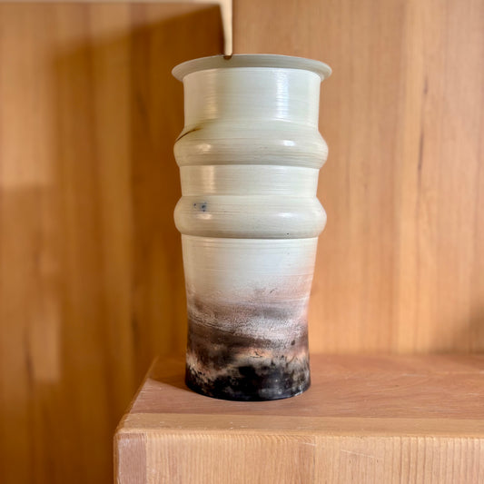 A tall porcelain saggar-fired vase in shades of white black and beige. Made by Hillit Wahlberg