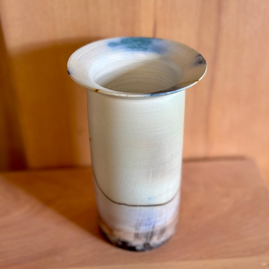 a porcelain saggar-fired vase in shades of white, peach and blue. Made by Hillit Wahlberg