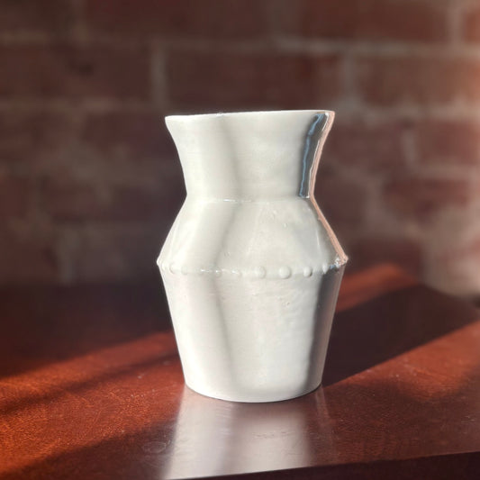 A white porcelain angular vase with an etching decoration and a gloopy glaze necklace-like finish. Made by Hillit Wahlberg