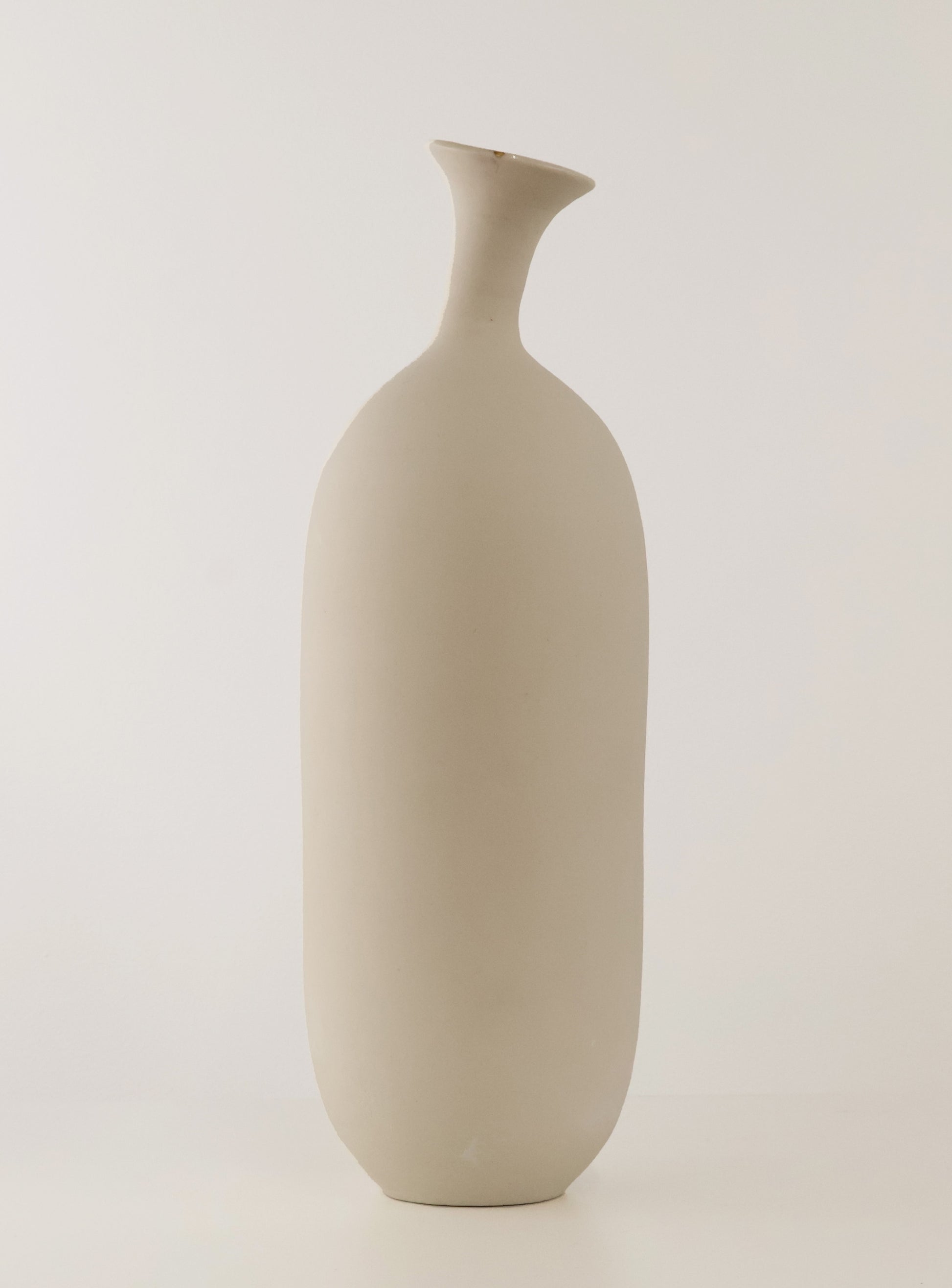 A minimalist, matte ceramic vase with a unique flared neck and rounded body, shown against a plain light gray studio background.